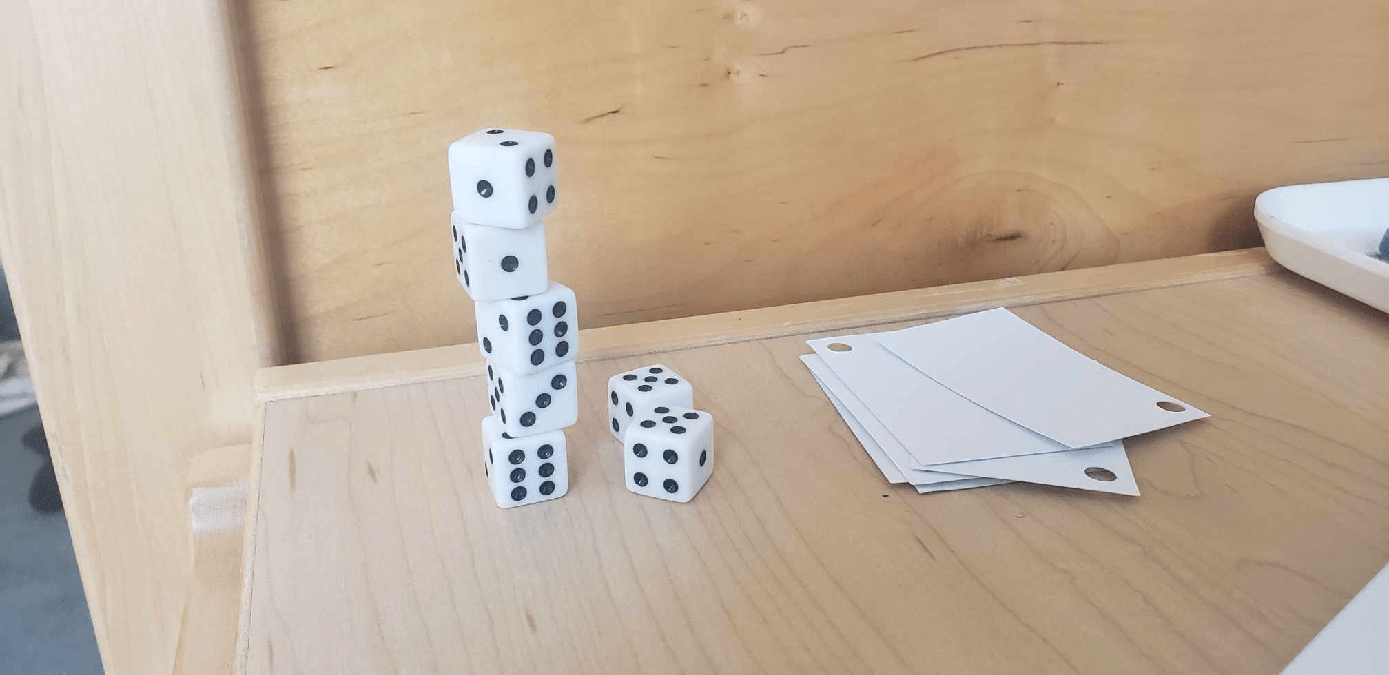 The game Stack. There is a tower of stacked dice next to a stack of cards.