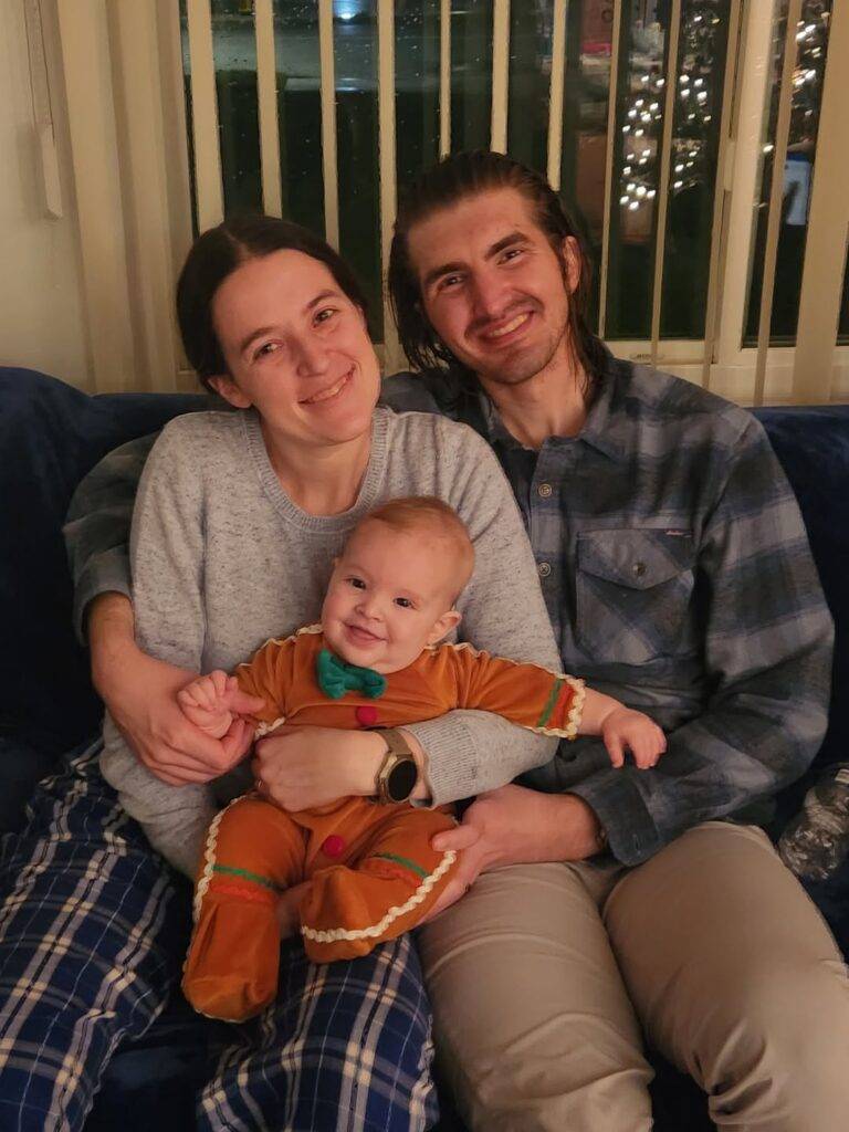 Photo of Jessica with her husband Zac and her son Leo who is wearing a gingerbread man costume